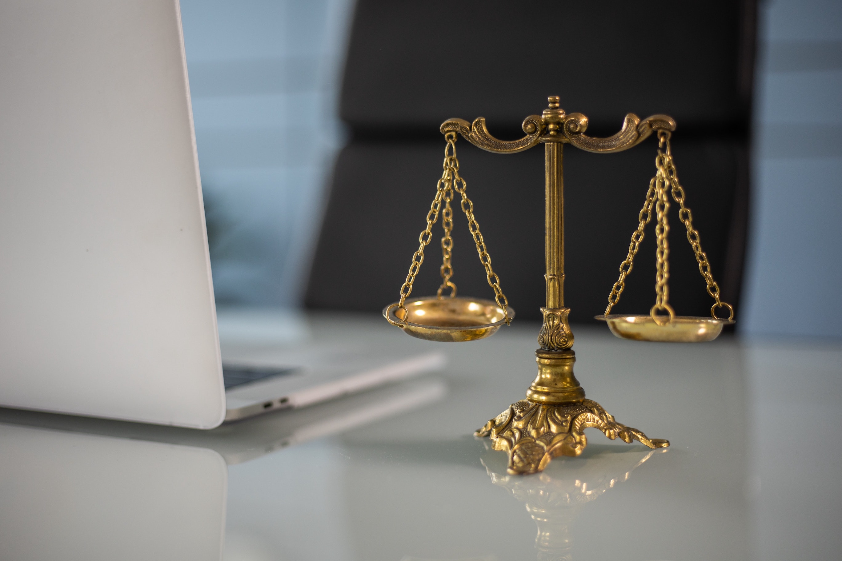 Law Scale sitting on a table next to a computer.